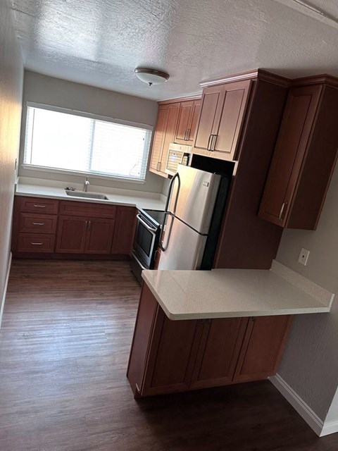 a kitchen with wooden cabinets and a stainless steel refrigerator